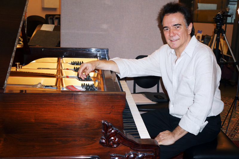 Luciano Alves com piano de cauda no estúdio.